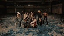 a group of people in cowboy hats are posing for a picture in an empty room