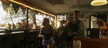 a man and a woman are dancing in a bar with a sign that says ' coca-cola ' on it