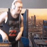 a man wearing headphones and a tank top is dancing in front of a city skyline .