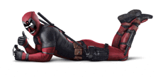 a man in a deadpool costume is laying on his back and giving a thumbs up