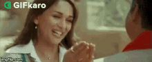 a woman is smiling while holding a man 's hand in a restaurant .