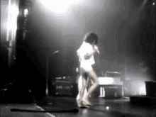 a woman is dancing on a stage with a microphone
