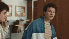 two young men are standing next to each other in a room