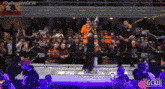 a man is standing in a wrestling ring holding a flag .