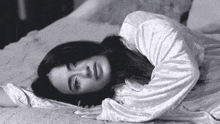 a black and white photo of a woman laying on the floor