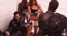 a man is taking a picture of a woman standing next to a man .