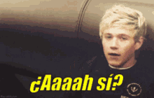 a man is sitting on a couch with the words aaah si written in yellow