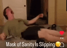 a man wearing a mask of sanity is laying on a bed