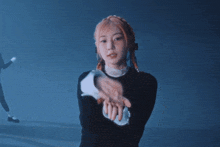 a woman in a black sweater is dancing in front of a crowd