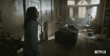 a netflix ad shows a woman standing in a living room and says oh shit