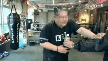 a man is holding a bottle of water in a boxing gym .