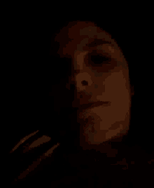 a close up of a woman 's face in the dark with her eyes closed