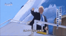 a man in a suit and tie is waving from the stairs of an airplane in a foreign language