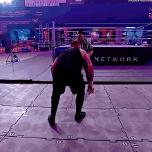 a man stands in front of a sign that says network on it