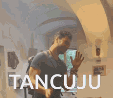 a man in a room with the word tancuju on the bottom