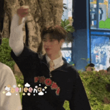 a man wearing a sweater that says propt is raising his fist in the air