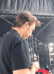 a man in a black shirt is playing a guitar