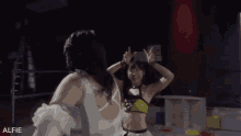 two women are wrestling in a ring and the word alfie is on the bottom
