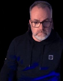 a man with glasses and a beard is pointing