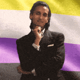 a man in a suit with his hand on his chin