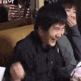 a man is laughing while sitting at a table with a woman in a restaurant .