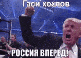 a man in a suit and tie is raising his fist in the air while screaming .