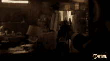 a man in a suit is pointing a gun at a woman in a kitchen in a showtime ad .