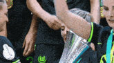a woman holding a trophy with a w on her shirt