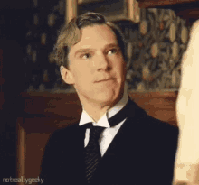a man in a suit and tie is looking at something