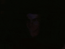 a man is wearing headphones in a dark room .