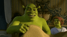 shrek is sitting on a bed next to a woman in a room .