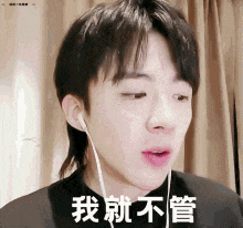 a young man wearing earphones is making a funny face while listening to music .