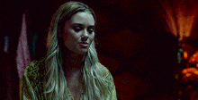 a woman is standing in a dark room looking at the camera .