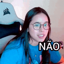 a woman wearing glasses and a blue shirt with the word nao on it