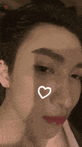 a close up of a woman 's face with a heart on her face