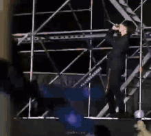 a man is hanging upside down from a scaffolding while holding a light