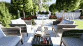 a table with a vase of flowers on it sits in a garden