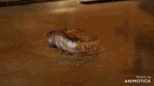 a steak is being cooked on a grill and the words made in animotica are on the bottom