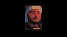 a blurry picture of a man with a beard wearing a hat .