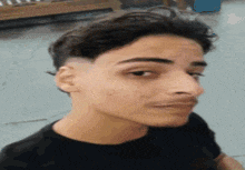 a close up of a young man 's face with a shaved head