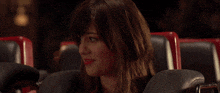 a woman is sitting in a roller coaster and looking at something .