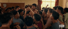 a large group of men are gathered in a room with the word kahar on the bottom