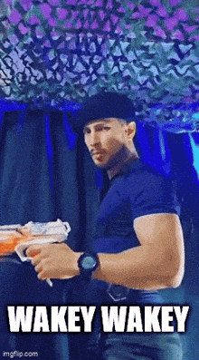 a man wearing a beret is holding a toy gun and the caption wakey wakey