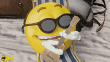 a smiley face with sunglasses is playing a guitar on the beach