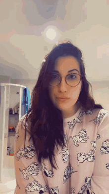 a woman wearing glasses and a dalmatian pajama top looks at the camera