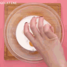 sugar is being poured into a glass bowl with a whisk