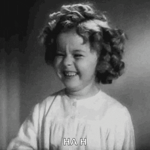 a black and white photo of a little girl laughing with the words `` hah '' written on the bottom .