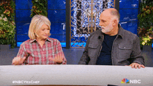 a man and a woman sitting at a table with a nbc logo on the bottom