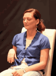 a woman sitting in a chair with her eyes closed