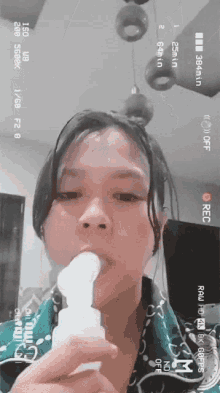 a girl is brushing her teeth with a device that says rec on the bottom